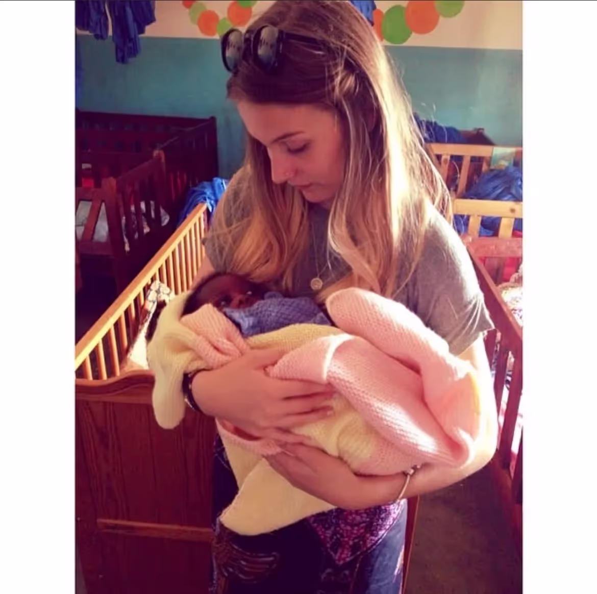 Marley holding a baby whilst in Malawi