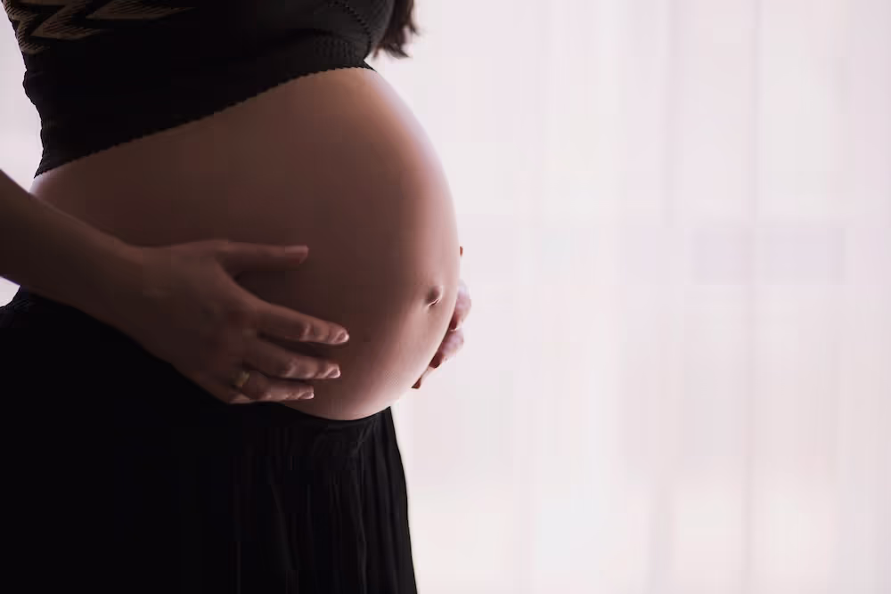 A mother holding her pregnant bump